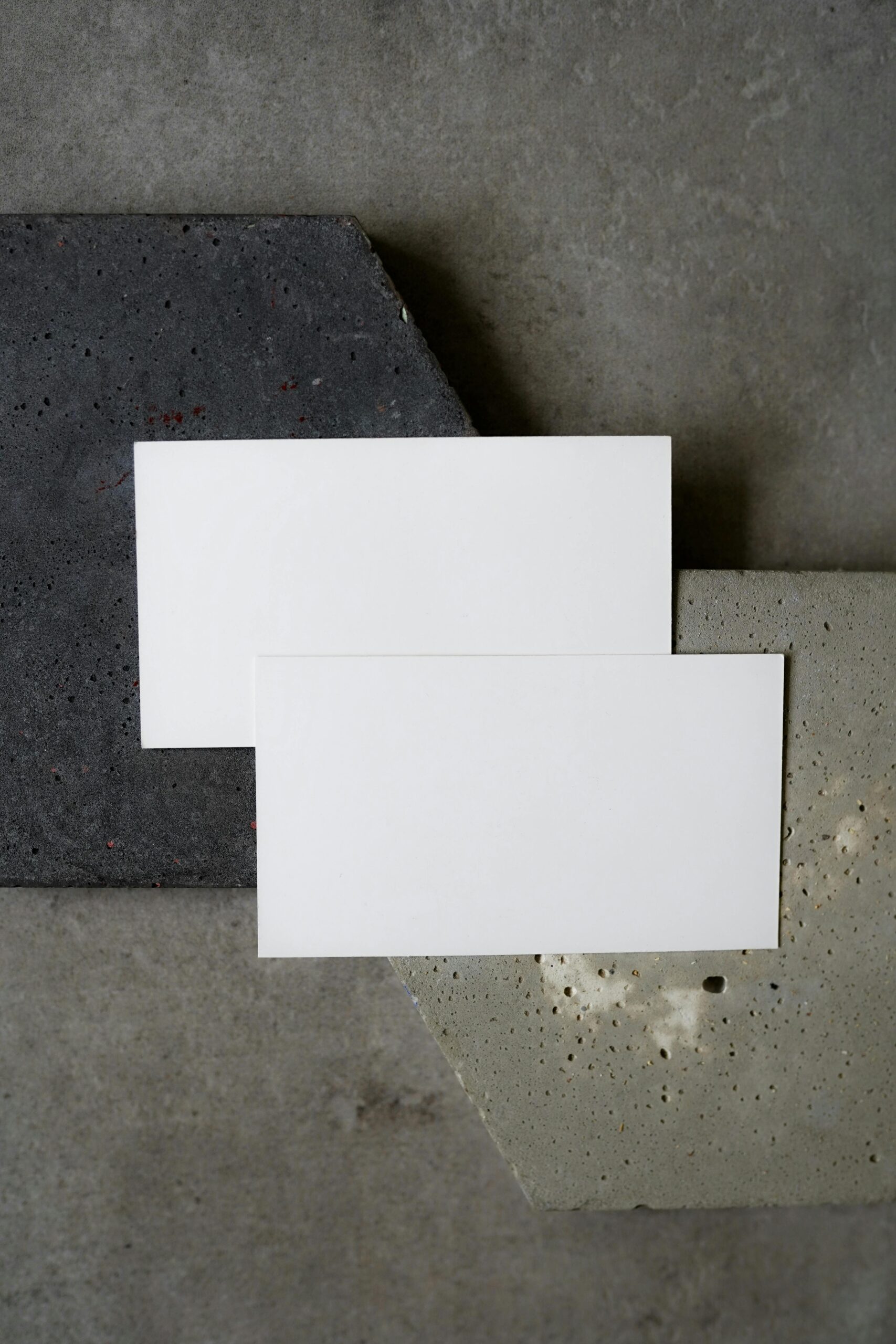 Simple flat lay of blank business cards on textured concrete background. Perfect for modern design presentations.